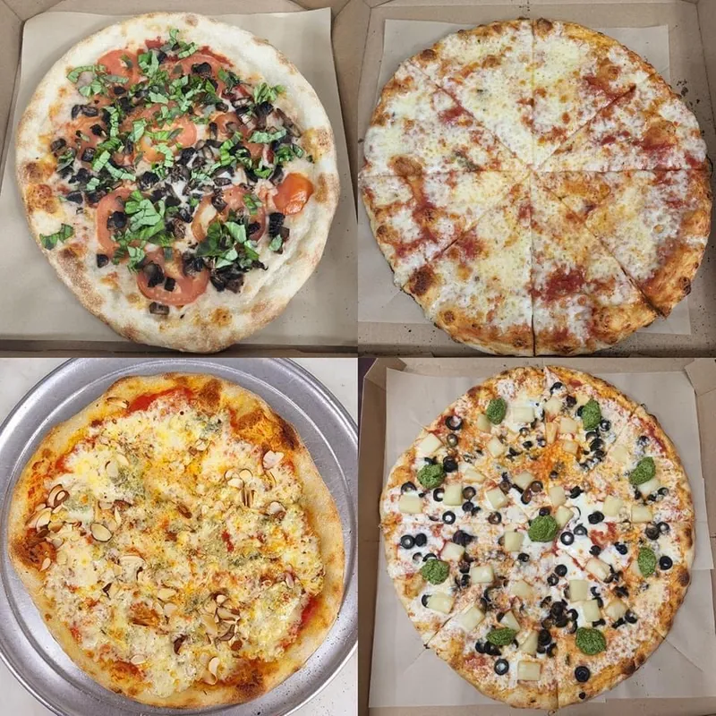 Four large pizzas with a variety of toppings